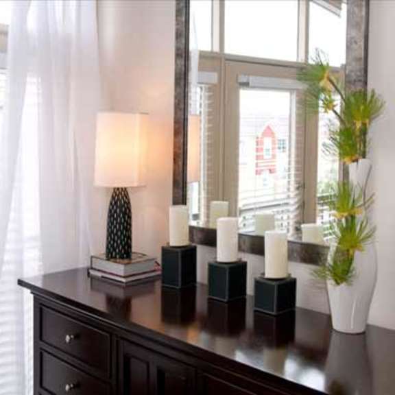 a table with candles and a mirror in front of a window