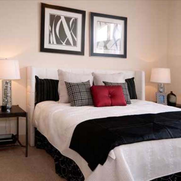 a bedroom with a bed and two pictures on the wall