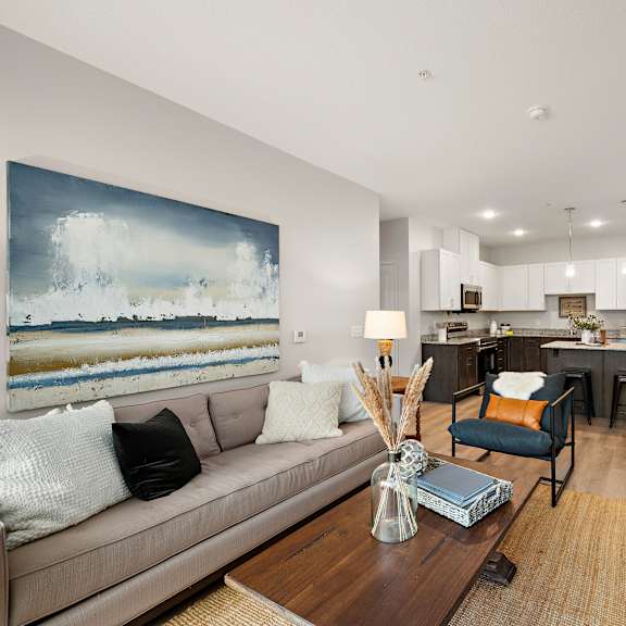 a living room with a couch and a table at the landing at amber fields apartments, minnesota, 55068