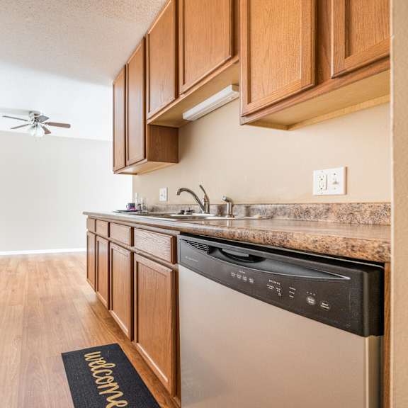 a kitchen with wooden cabinets and stainless steel appliances at heritage hills apartments, bloomington, mn