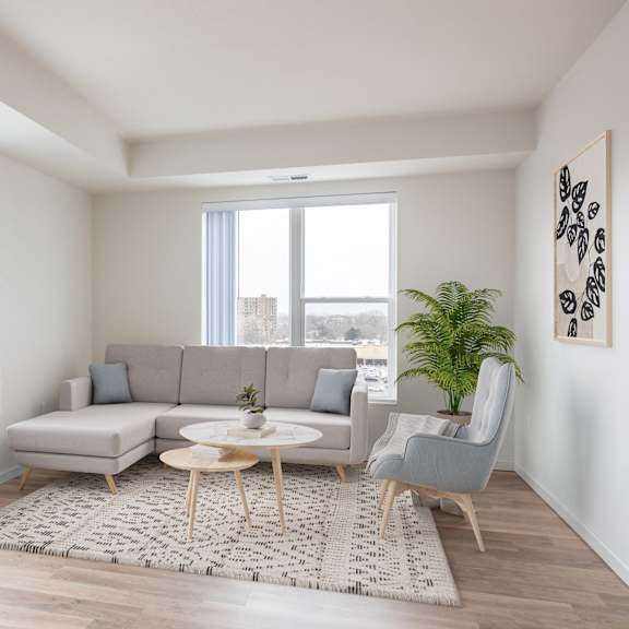 a living room with a gray couch and a rug and large windows