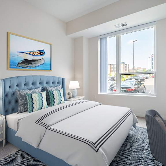 a bedroom with a large window and a desk with a computer at sonder point 50+ apartments, brooklyn center, mn