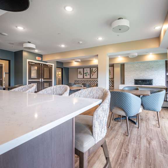 a resident clubhouse with a kitchen and dining area at sonder point 50+ apartments, brooklyn center, mn