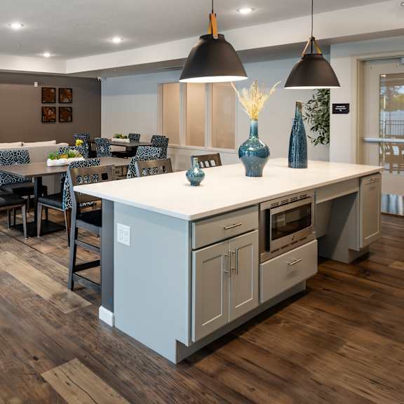 a kitchen with a large island and a dining room with a table and chairs