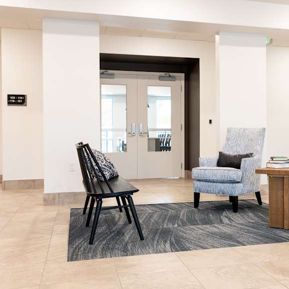 a lobby with chairs and a table in front of a door