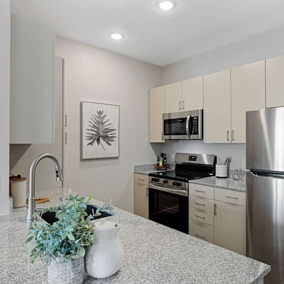 a kitchen with a stainless steel refrigerator, microwave, and oven.