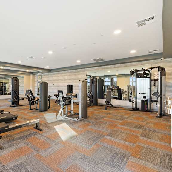 a gym with a variety of equipment including treadmills, weights, and exercise machines at agave house apartments, arizona