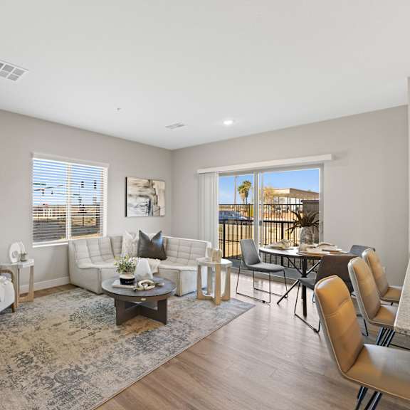 a living room with couches and chairs and a table and a balcony at agave house apartments, casa grande, 85122