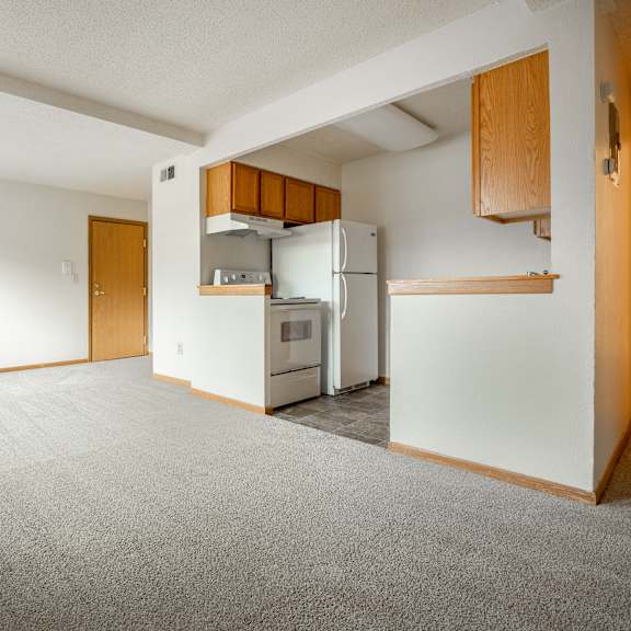 an empty living room with a kitchen in the corner at ames lake neighborhood apartments, st. paul, mn, 55106