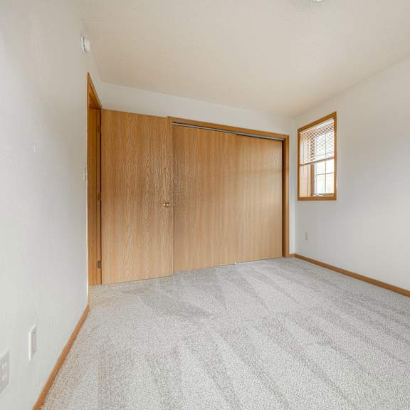 a room with a carpeted floor and a wooden door at ames lake neighborhood apartments, minnesota, 55106