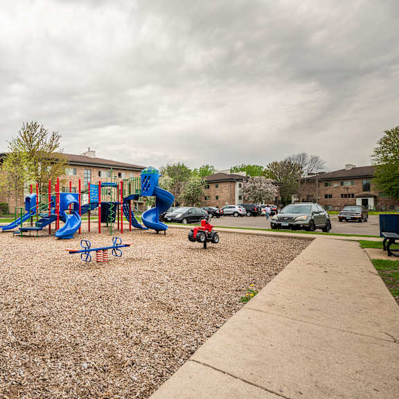 a playground in a park in front of a building at ames lake neighborhood apartments, minnesota