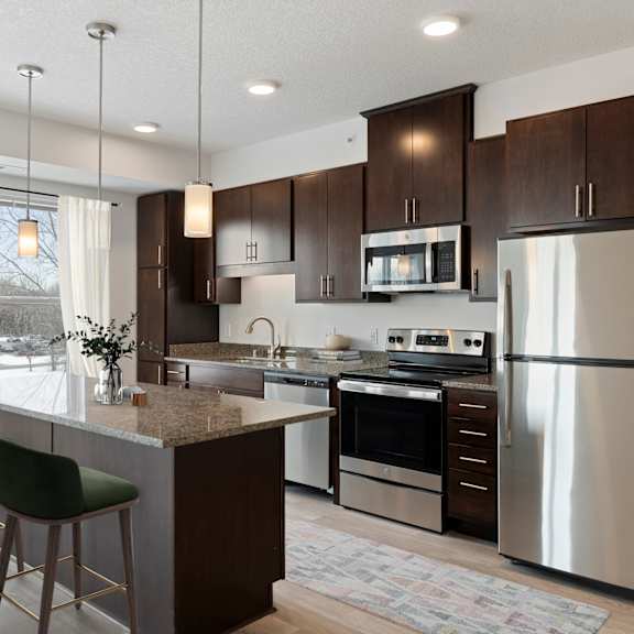 a kitchen with stainless steel appliances and a marble counter top