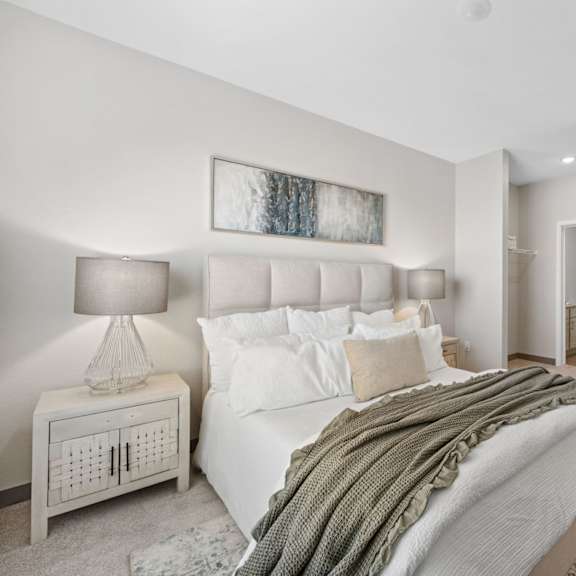 a bedroom with a large bed and a nightstand with a lamp at copa flats apartments, maricopa, az, 85138