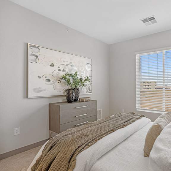a bedroom with a large bed and a painting on the wall at copa flats apartments, maricopa