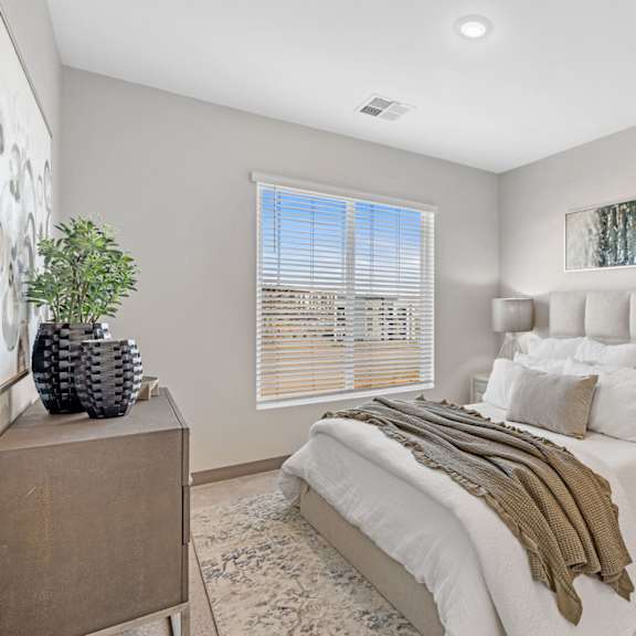 a bedroom with a large bed and a wooden dresser at copa flats apartments, maricopa, 85138