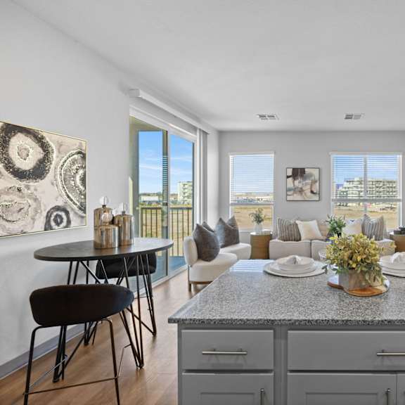 a modern kitchen with a dining table and chairs at copa flats apartments, maricopa, az, 85138