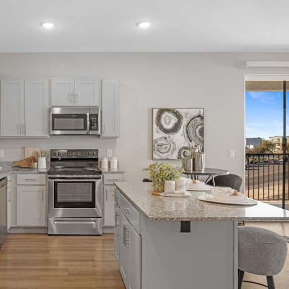 a modern kitchen with stainless steel appliances and white cabinets at copa flats apartments, maricopa, az, 85138
