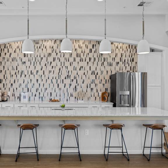 a kitchen with a white counter and bar stools at copa flats apartments, maricopa, arizona