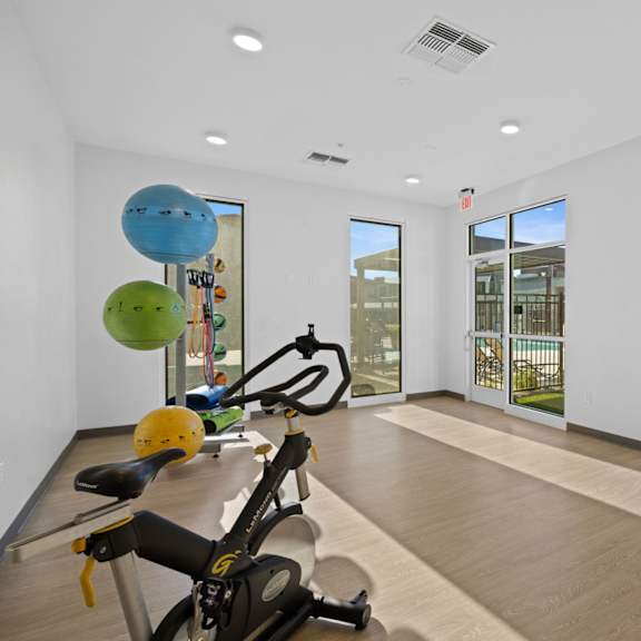 a gym with exercise equipment and a view of a building outside at copa flats apartments, arizona