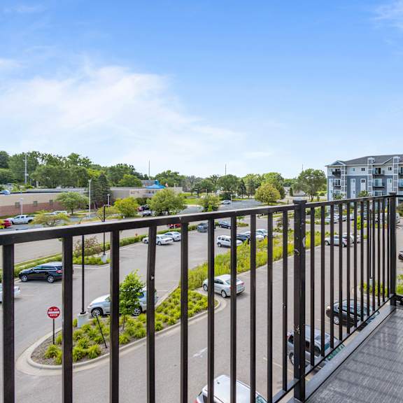 a balcony with a view of a parking lot and a building at eastgate apartments, rochester