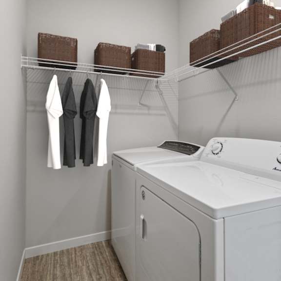 a white washer and dryer in a laundry room with a rack of clothes at eastgate apartments, rochester, minnesota