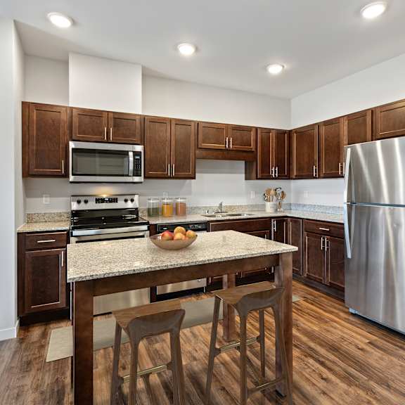 a kitchen with stainless steel appliances and a granite counter top at eastgate apartments, rochester, mn