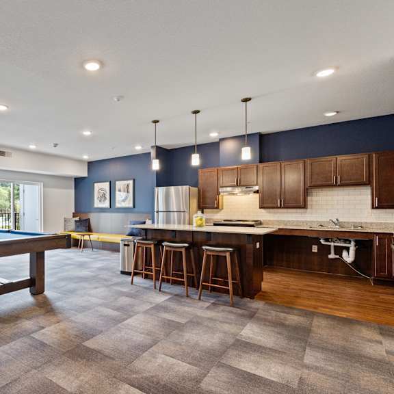 a game room with a pool table and a kitchen at eastgate apartments, rochester, mn, 55904