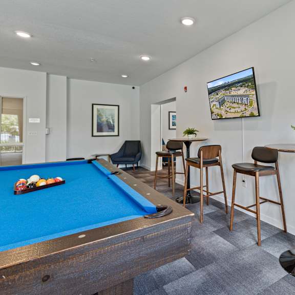 a games room with a pool table and bar with stools at eastgate apartments, minnesota, 55904