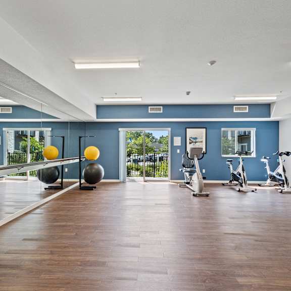 the gym with exercise equipment and mirrors at the belgard apartments at eastgate apartments, rochester, mn