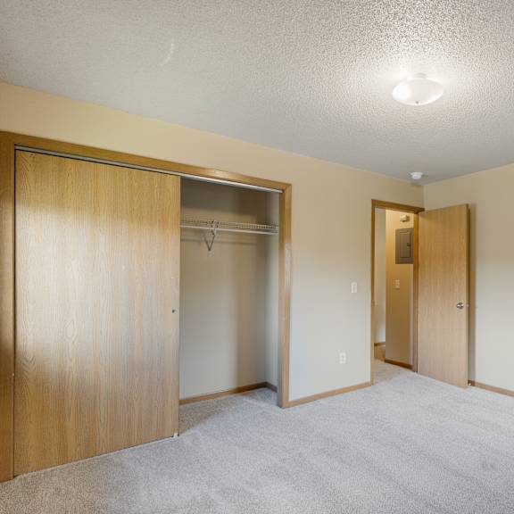 a room with a carpeted floor and two open doors at ames lake neighborhood apartments, st paul 55106