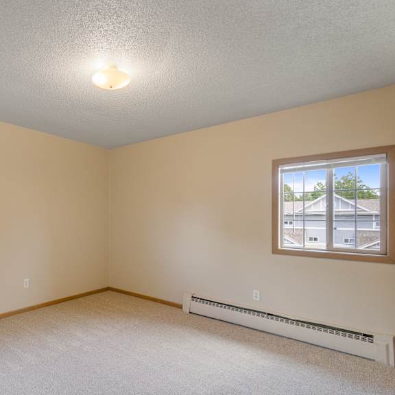 a room with a window and a wall-mounted air conditioner at ames lake neighborhood apartments, minnesota