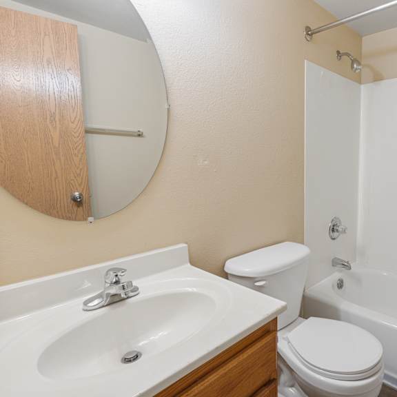 a white toilet sits next to a sink in a bathroom at ames lake neighborhood apartments, minnesota, 55106
