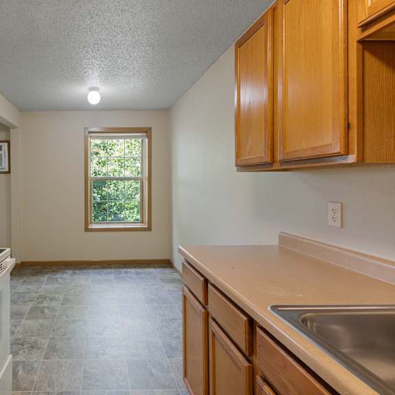 a kitchen with a white oven and a window at ames lake neighborhood apartments, st paul, mn, 55106