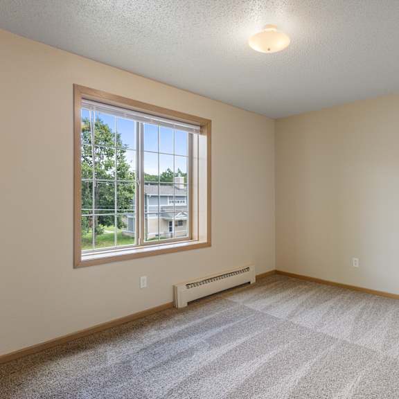 a room with a window and a carpeted floor at ames lake neighborhood apartments, st paul 55106