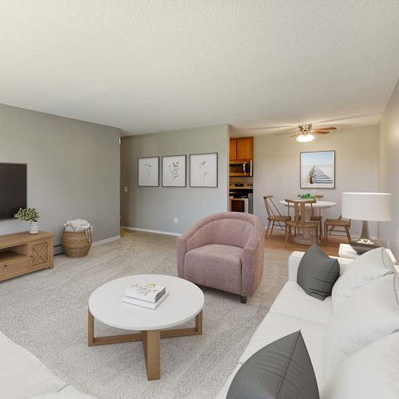 a living room with a white couch, a pink chair, a wooden coffee table, and a flat-screen tv at heritage hills apartments, bloomington minnesota
