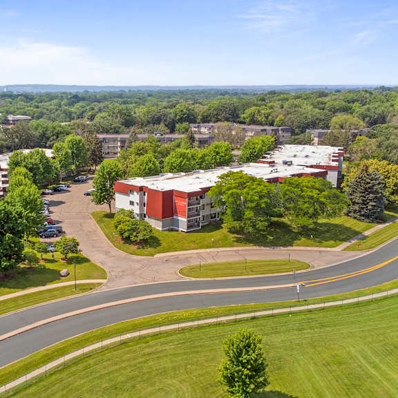 an aerial view of a campus with buildings and a road at heritage hills apartments, minnesota, 55437
