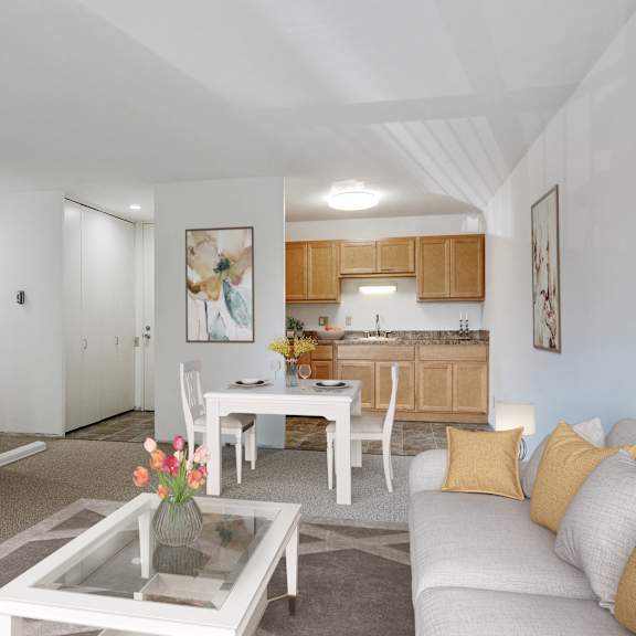 a living room with a couch and a table and a kitchen at humboldt senior 55+ apartments, saint paul