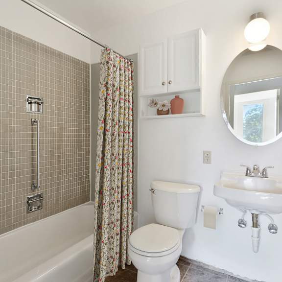 a white bathroom with a shower and a toilet and a sink at humboldt senior 55+ apartments, minnesota
