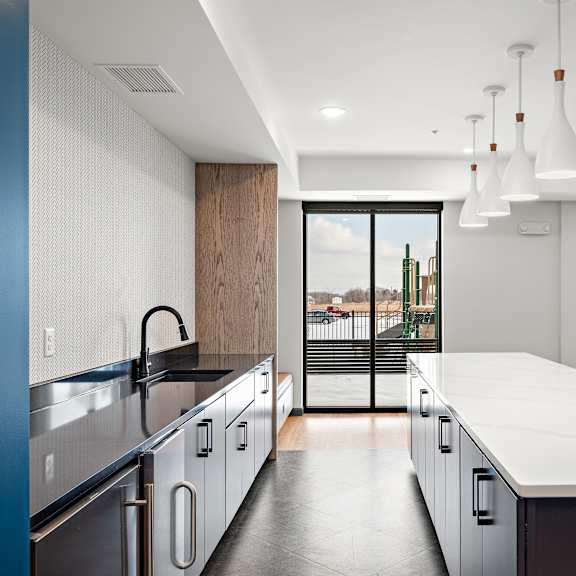 a modern kitchen with a large island and stainless steel appliances. at the landing at amber fields apartments, minnesota, 55068