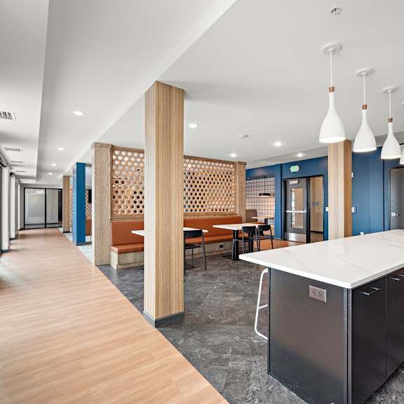 a long hallway with a kitchen area at the end. at the landing at amber fields apartments, rosemount, mn