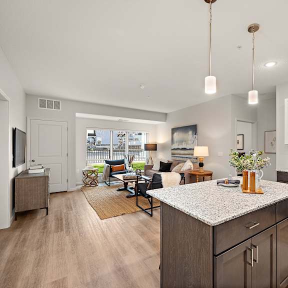 a modern kitchen with dark wood cabinets and a granite countertop at the landing at amber fields apartments, rosemount, mn