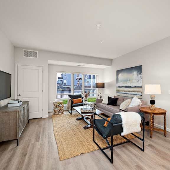 a living room with a couch, chair, and television at the landing at amber fields apartments, rosemount, mn, 55068