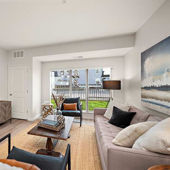 a living room with a brown sofa and a wooden coffee table at the landing at amber fields apartments, minnesota, 55068