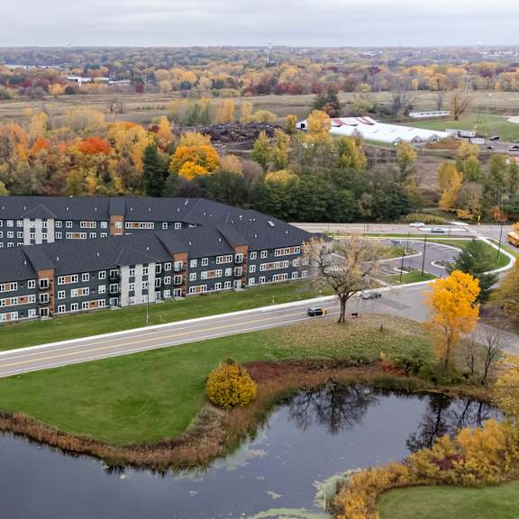 an aerial view of a londin crossing next to a pond