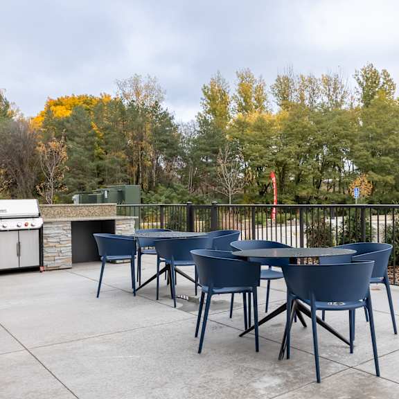 outdoor area with tables and chairs and a grill