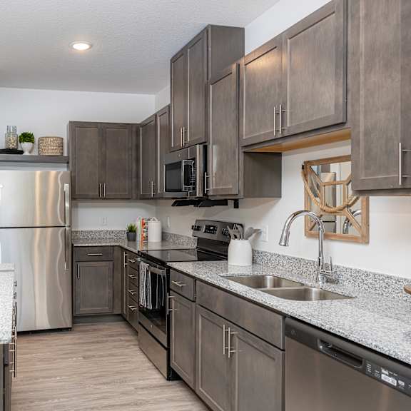 an open kitchen with stainless steel appliances and granite counter tops