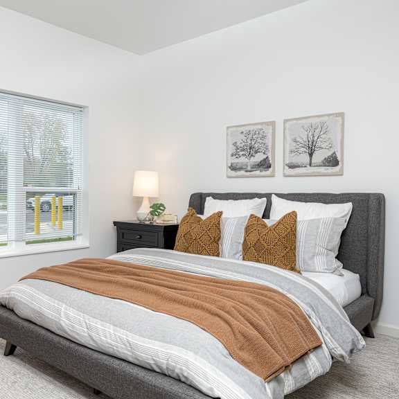 a bedroom with a bed and two windows