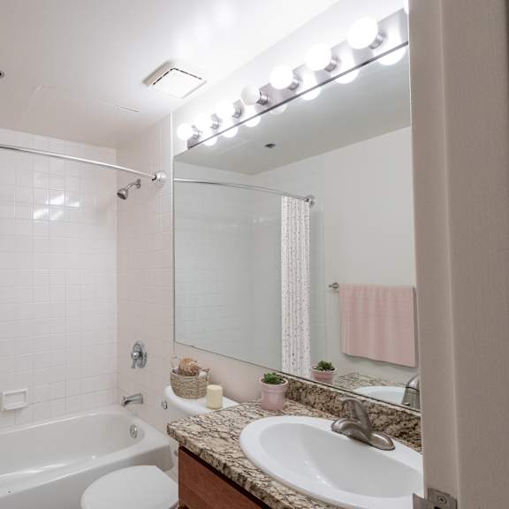 a bathroom with a sink and a tub and a mirror