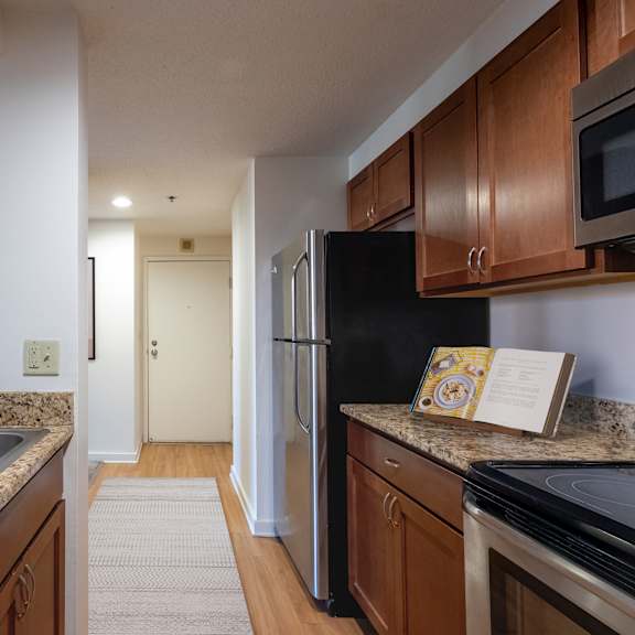 a kitchen with granite counter tops and a stainless steel refrigerator