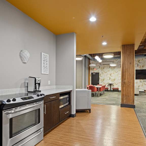 a kitchen and living room with a stove and a tv